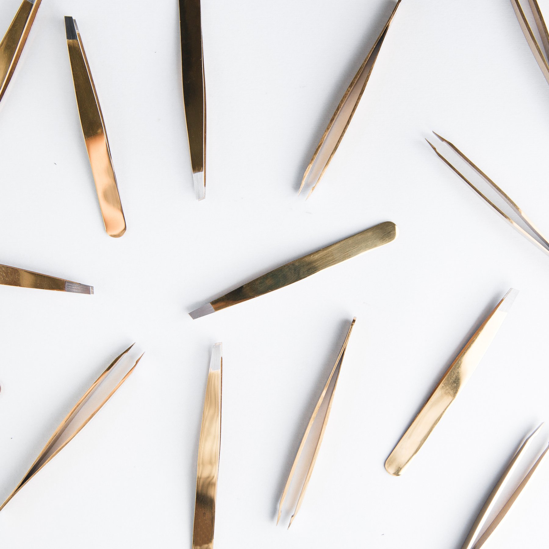 The set of tools of a cosmetologist. Tweezers on a white background. Tool in a black leather case. The layout of the lashes to the eyebrows.